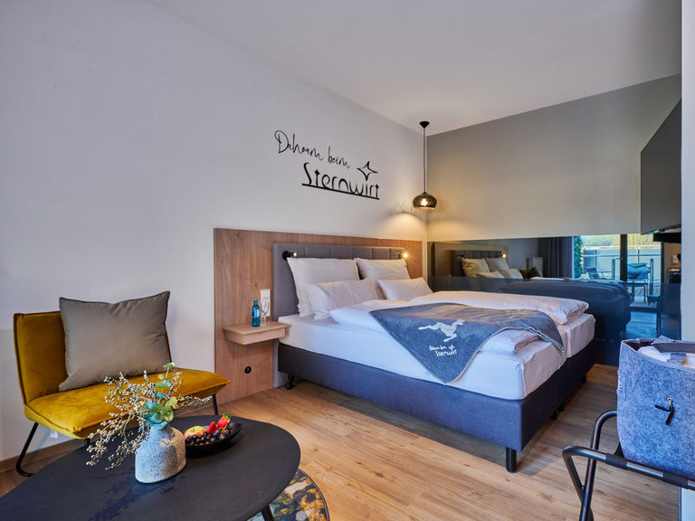 Ein geschmackvoll eingerichtetes Zimmer im Sternwirt mit weichen Kissen auf einem stilvollen Bett.