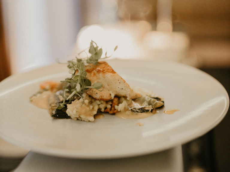 Ein weißer Teller mit Speisen steht auf einem stilvollen Tisch.