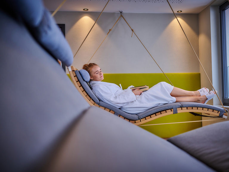 Eine Frau entspannt auf einer Hängeliege im Landhotel Sternwirt in Franken