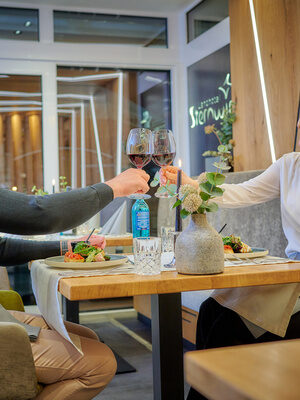 Ein fröhliches Paar genießt kulinarische Erlebnisse in einem eleganten Restaurantambiente.