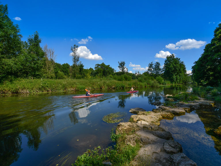 Kanus gleiten über einen Fluss in der natürlichen Sommerlandschaft.