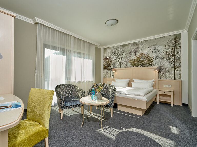 Ein komfortables Hotelzimmer mit einem stilvollen Bett und einem praktischen Schreibtisch.