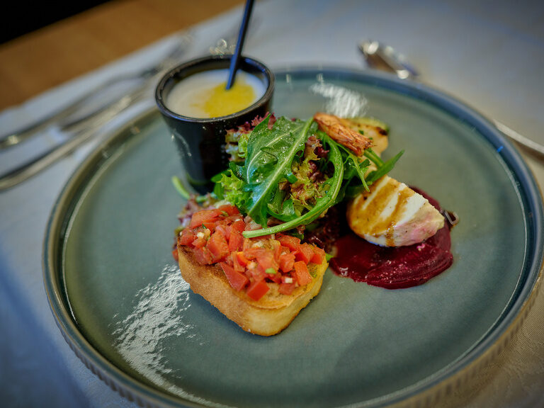Ein kunstvoll zubereitetes Gericht auf einem eleganten Teller in einem gehobenen Restaurant.