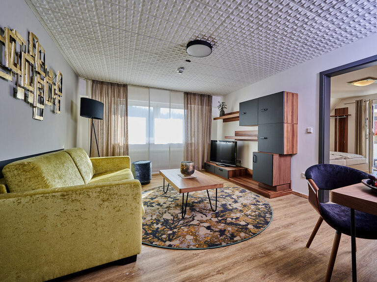 Ein gemütliches Wohnzimmer mit einem eleganten Sofa im modernen Hotelzimmer.